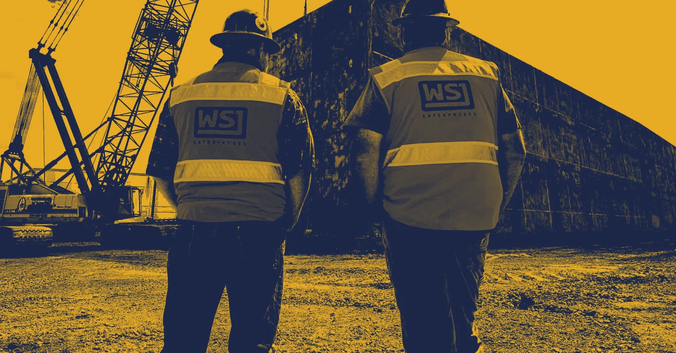 Two WSJ Enterprises workers in hard hats and marked vests on a jobsite